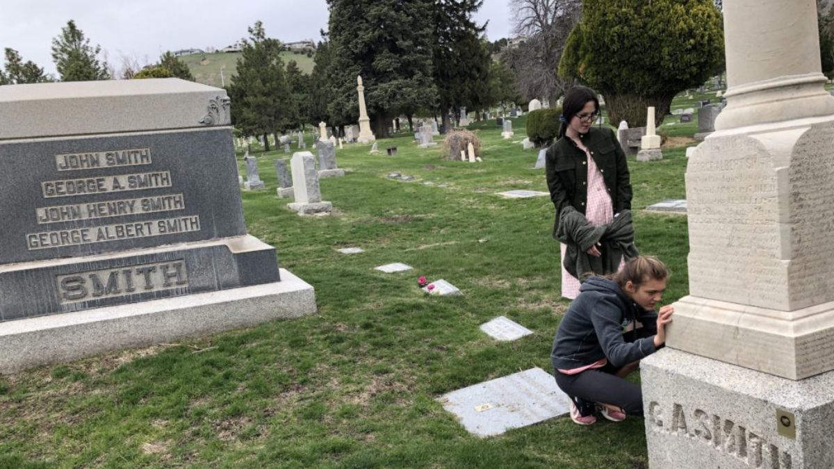 Two girls examine Latter-day Saint pioneer gravesites at the Salt Lake City Cemetery