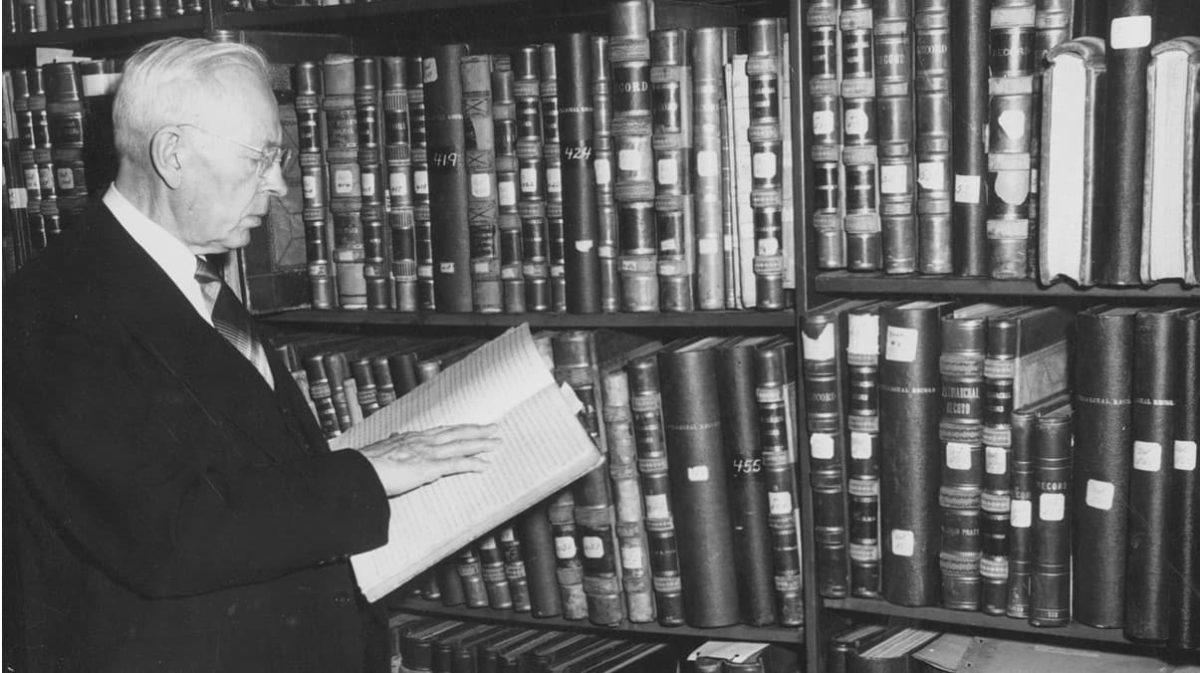 Joseph Fielding Smith examining a manuscript in a library.